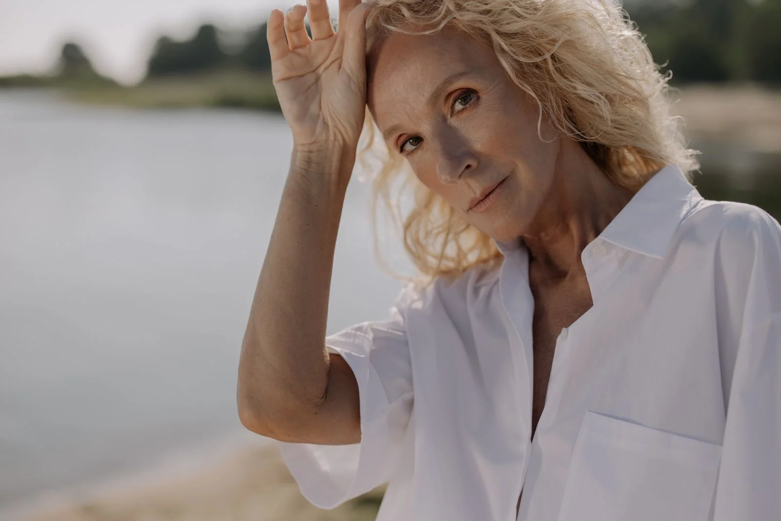 Retrato de uma mulher idosa com cabelo loiro posando ao ar livre sob a luz do sol, ilustrando estratégias naturais para aliviar fogachos