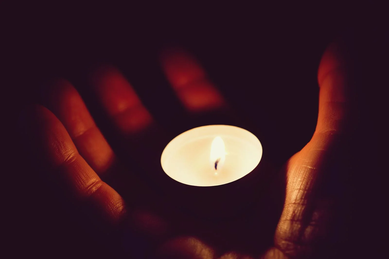 A serene image of hands gently holding a glowing candle, creating a warm and peaceful atmosphere — Dia Mundial de Prevenção ao Suicídio