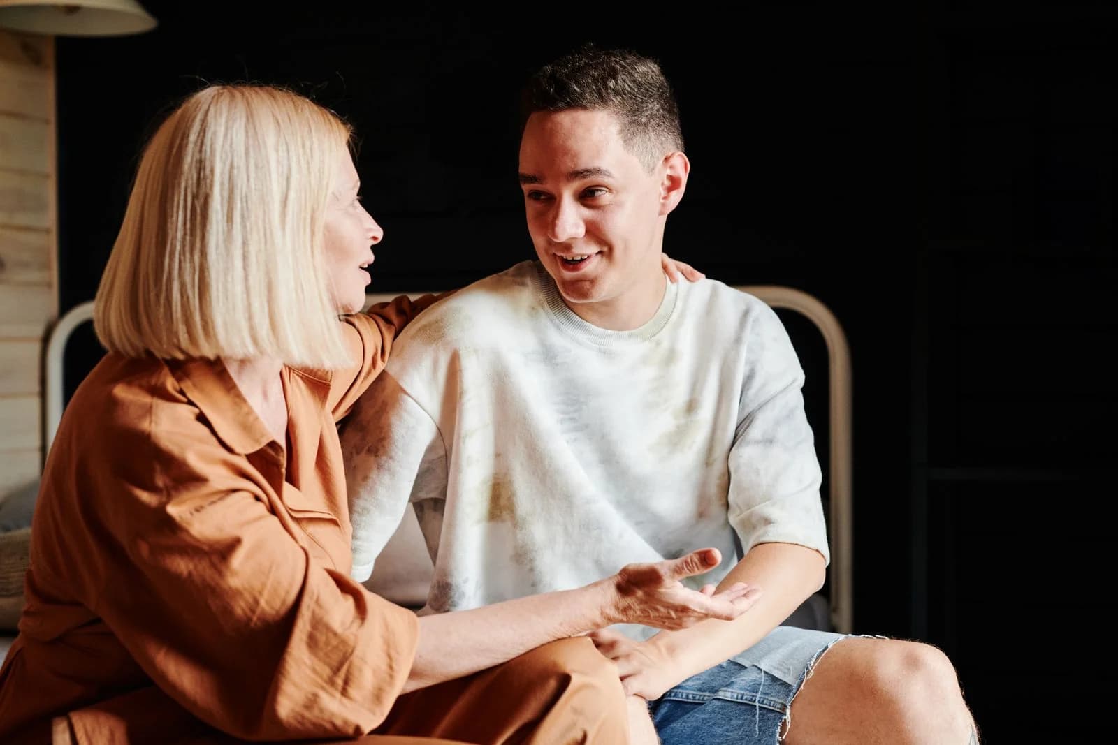 A mother and son engage in a warm, heartfelt conversation indoors, ilustrando o fenômeno da geração canguru