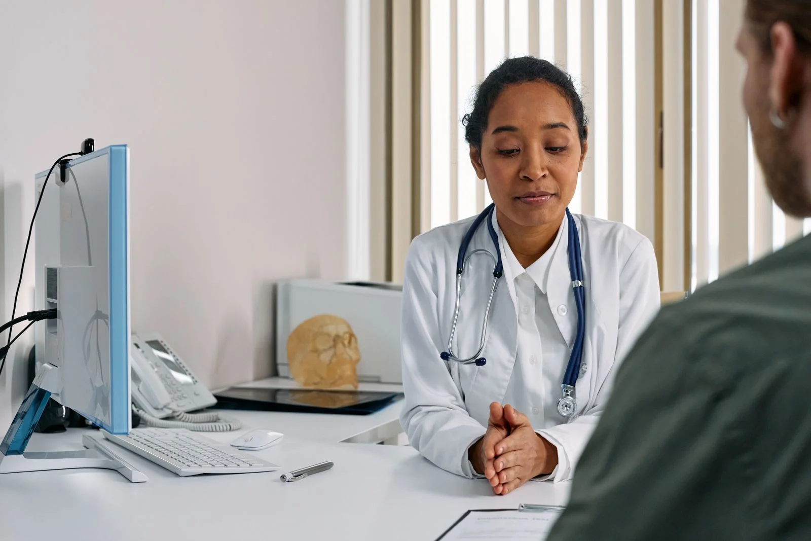A female doctor consulting a patient in a modern medical office setting, ilustrando quem pode fazer terapia de reposição hormonal